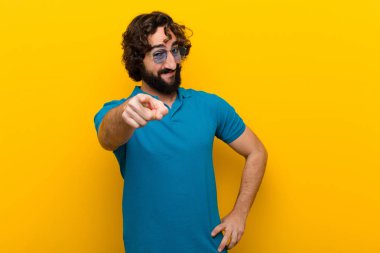 Genç, deli bir adam kameraya bakıyor. Tatmin olmuş, kendine güvenen, dost canlısı bir gülümsemeyle. Turuncu duvara karşı seni seçiyor.