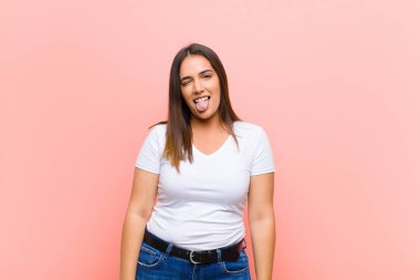 Genç, güzel İspanyol kadın gülümsüyor, seni selamlıyor ve başarılı bir anlaşma için el sıkışmayı teklif ediyor, pembe duvara karşı işbirliği konsepti.