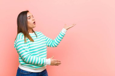 Genç ve güzel İspanyol bir kadın opera icra ediyor ya da konserde şarkı söylüyor, pembe duvara karşı romantik, sanatsal ve tutkulu hissediyor.