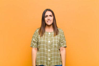 Genç ve güzel bir kadın şaşkın ve kafası karışmış görünüyor. Gergin bir hareketle dudağını ısırıyor. Sorunun cevabını bilmiyor.