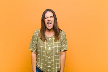 Genç, güzel bir kadın agresif bir şekilde bağırıyor. Kızgın, sinirli, öfkeli ya da sinirli görünüyor. Çığlık atıyor.
