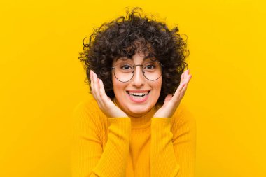 Genç, güzel afro kadın şok olmuş ve heyecanlı, gülen, şaşırmış ve mutlu çünkü beklenmedik bir sürpriz