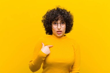 Genç, güzel afro kadın şok olmuş ve ağzı açık, kendini işaret ederek şaşırmış görünüyor.