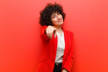 Genç, güzel afro kadın kameraya bakıyor. Tatmin olmuş, kendine güvenen, dost canlısı bir gülümsemeyle. Seni seçiyor.