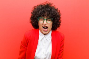 Genç, güzel afro kadın agresif bir şekilde bağırıyor, çok kızgın, hayal kırıklığına uğramış, öfkeli ya da rahatsız olmuş görünüyor.