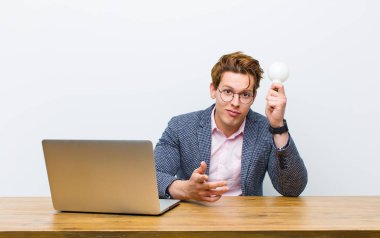 Genç kızıl saçlı işadamı masasında çalışıyor.