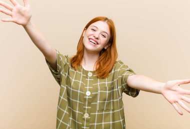 Genç kızıl saçlı güzel bir kadın neşeyle gülümsüyor sıcak, dostça, sevgi dolu bir kucaklama yapıyor, mutlu ve sevimli hissediyor.