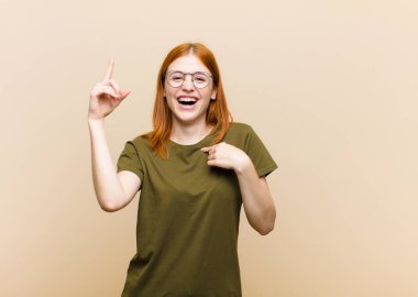 Genç kızıl saçlı güzel bir kadın gururlu ve şaşırmış hissediyor, kendine güvenen, başarılı bir numara gibi hisseden.