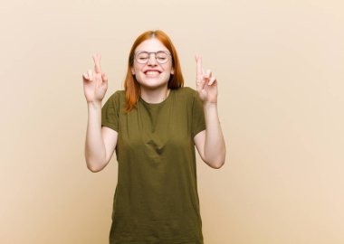 Genç kızıl saçlı güzel bir kadın gergin ve umutlu, şans diliyor ve dua ediyor.