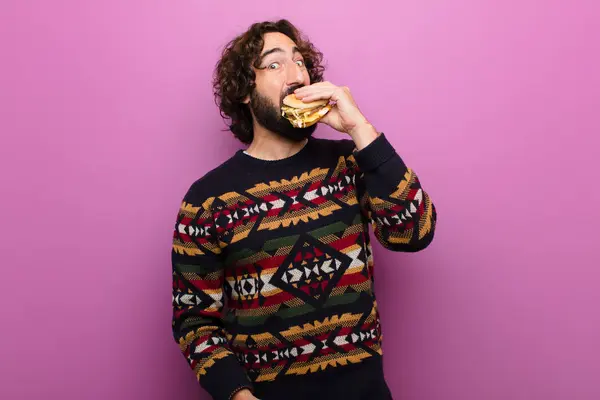 年轻疯狂的大胡子男人吃汉堡包 — 图库照片