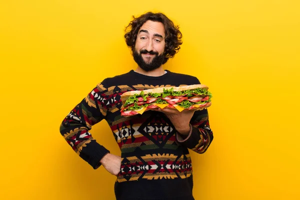 young crazy bearded man with a giant sandwich.
