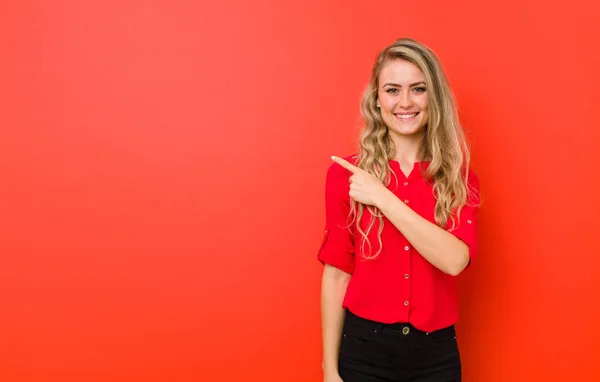 Joven Rubia Sonriendo Alegremente Sintiéndose Feliz Señalando Hacia Lado Hacia —  Fotos de Stock