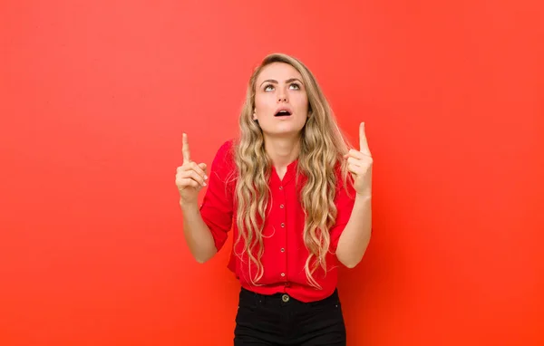 Young Blonde Woman Looking Shocked Amazed Open Mouthed Pointing Upwards — ストック写真