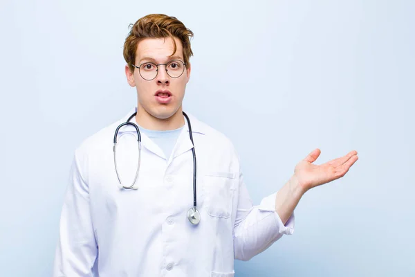 Young Red Head Doctor Looking Surprised Shocked Jaw Dropped Holding — Stock Photo, Image