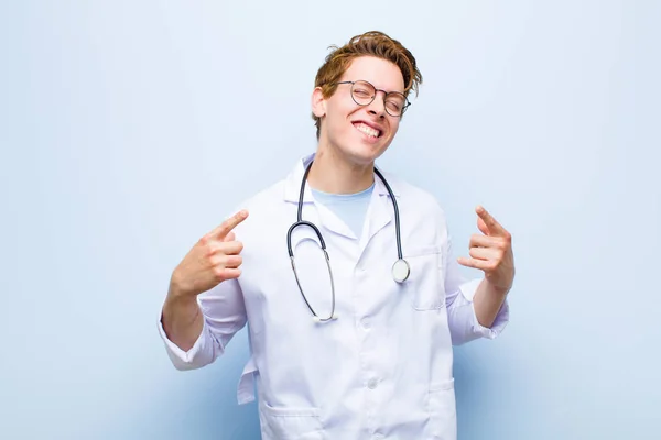 Jovem Médico Cabeça Vermelha Sorrindo Confiantemente Apontando Para Próprio Sorriso — Fotografia de Stock