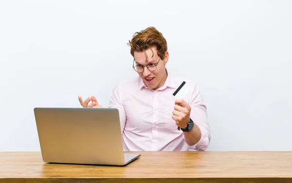 Joven Hombre Negocios Pelirrojo Trabajando Escritorio Con Una Tarjeta Crédito — Foto de Stock