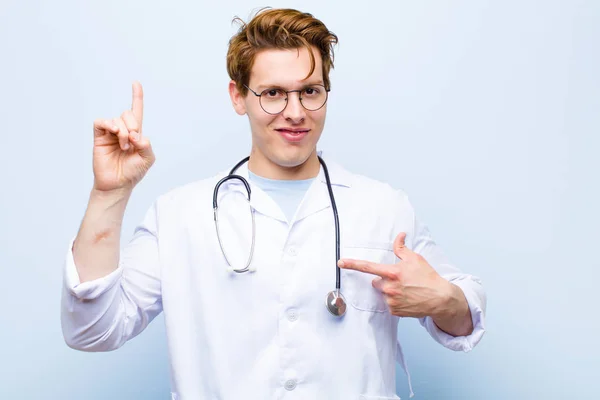Young Red Head Doctor Feeling Proud Surprised Pointing Self Confidently — Stock Photo, Image