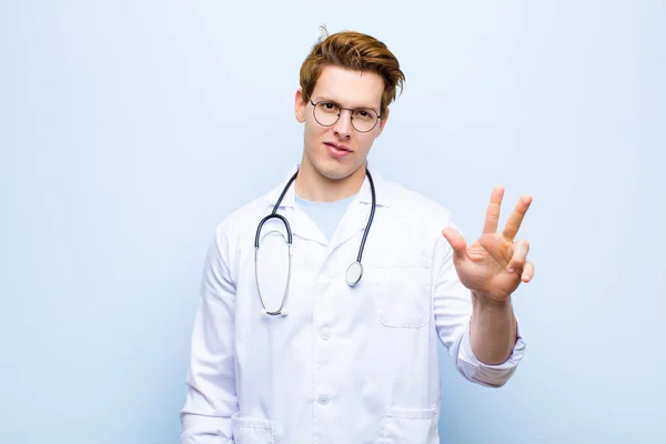 Young Red Head Doctor Smiling Looking Friendly Showing Number Three — Stock Photo, Image