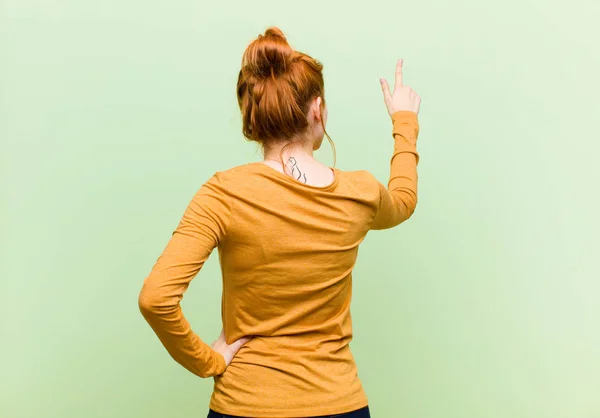 Junge Hübsche Rote Frau Steht Und Zeigt Auf Objekt Kopierraum — Stockfoto