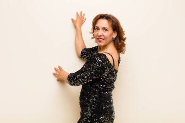 Orta yaşlı güzel bir kadın izole edilmiş ve düz arkaplanda poz veriyor.