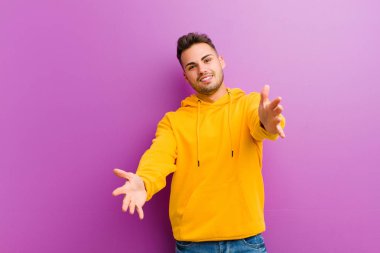 Mor arka planda sıradan görünüşlü genç bir İspanyol.