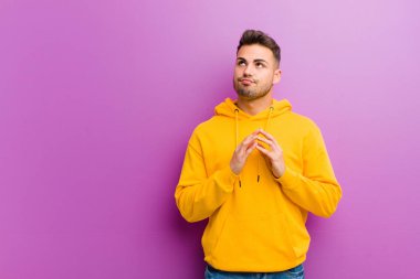 Mor arka planda sıradan görünüşlü genç bir İspanyol.