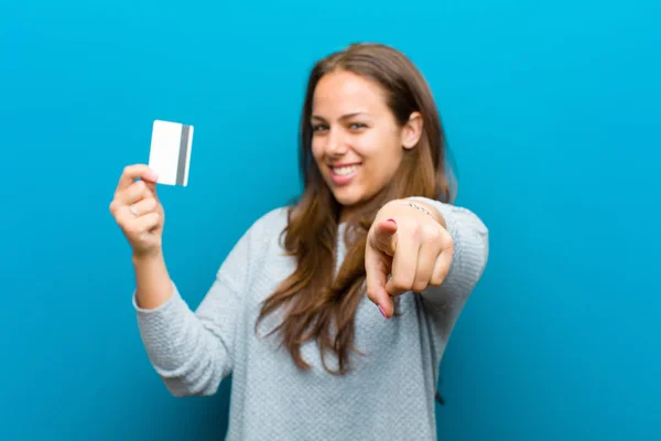 Jeune femme avec une carte de crédit sur fond bleu — Photo