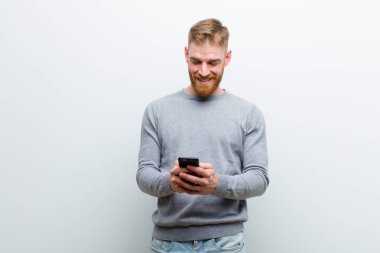 beyaz arka plan karşı bir akıllı telefon ile genç kırmızı kafa adam