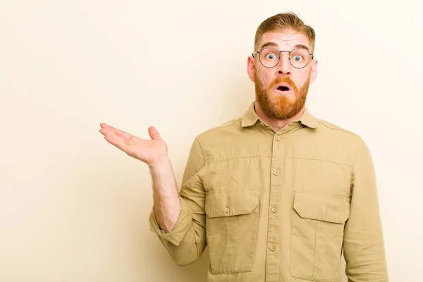 Young Red Head Man Looking Surprised Shocked Jaw Dropped Holding — Stock Photo, Image