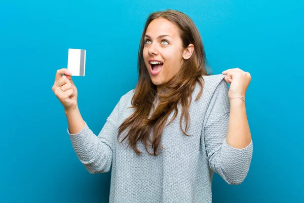 Fiatal nő bankkártyával kék háttérrel — Stock Fotó