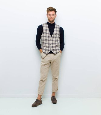 Genç adam beyaz arka planda poz veriyor.