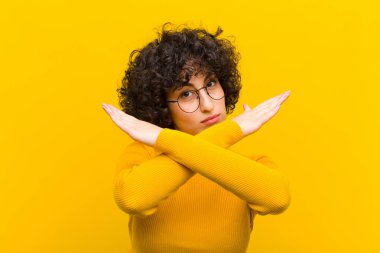 Genç, güzel, afro bir kadın senin tavırlarından rahatsız ve bıkkın görünüyor. Yeter artık! Eller önde çapraz, durmanı söylüyor.