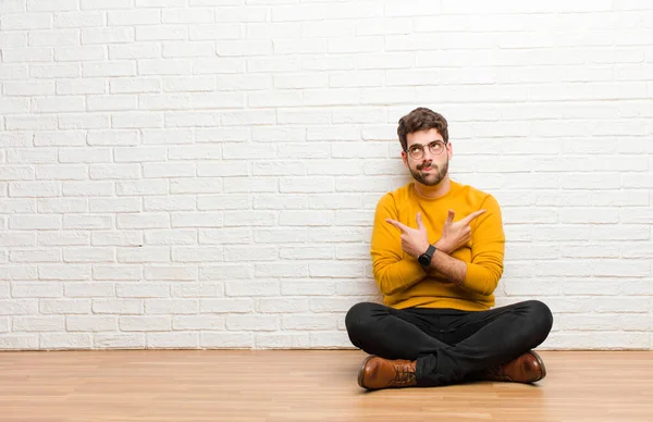 Junger Gutaussehender Mann Sitzt Auf Dem Fußboden Vor Einer Ziegelwand — Stockfoto