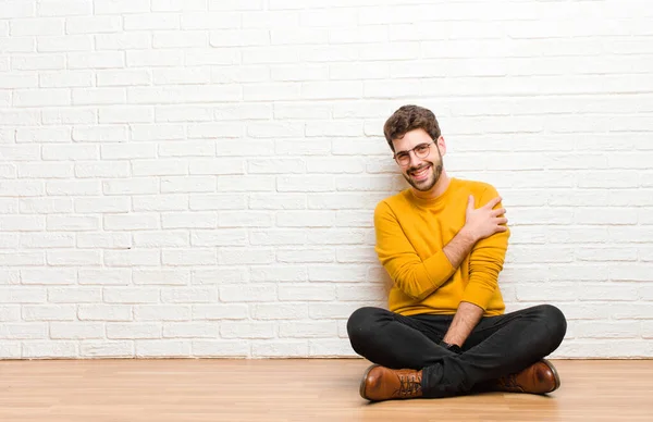 Jovem Homem Bonito Sentado Chão Casa Contra Textura Parede Tijolo — Fotografia de Stock