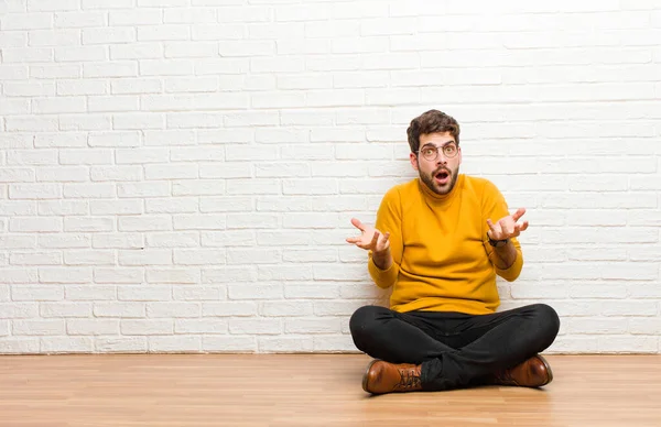 Joven Hombre Guapo Sentado Suelo Casa Contra Textura Pared Ladrillo — Foto de Stock