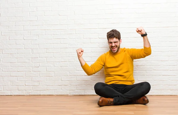 Joven Hombre Guapo Sentado Suelo Casa Contra Textura Pared Ladrillo — Foto de Stock