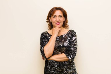 Orta yaşlı güzel bir kadın izole edilmiş ve düz arkaplanda poz veriyor.