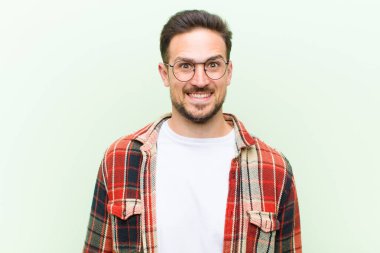 Genç yakışıklı adam mutlu ve hoş bir şekilde şaşırmış görünüyor. Büyülenmiş ve şok olmuş bir ifadeyle heyecanlanıyor.