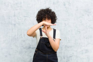 Genç, güzel afro kadın ciddi, sert, kızgın ve canı sıkkın görünüyor.