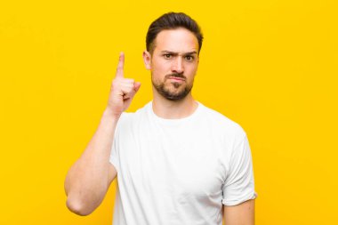 Genç yakışıklı bir adam, turuncu duvara karşı 