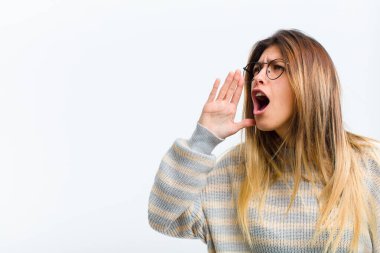 Genç, güzel bir kadın öfkeyle ve yüksek sesle kenardaki boşluğu kopyalamak için bağırıyor. Ağız yanında beyaz arka plan var.