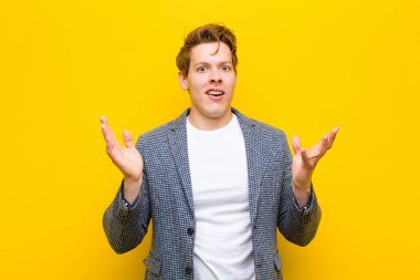 Genç kızıl saçlı adam şok olmuş ve şaşkın görünüyordu. Turuncu arka planda inanılmaz bir şey fark ettiğinde, ağzı açık kalmıştı.