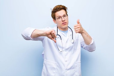 Genç kızıl kafalı doktor, kafası karışık, bilgisiz ve kararsız hissediyor. Mavi duvara karşı iyi ve kötü seçenekleri tartıyor.