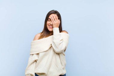 Genç ve güzel bir kadın gülüyor ve alnına şaplak atıyor. Unutmuşum yoksa mavi arka planda yaptığım aptalca bir hataydı. 