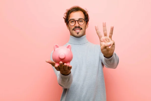 Jovem Bonito Homem Com Porquinho Banco Contra Rosa Parede Plana — Fotografia de Stock