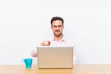 Genç ve yakışıklı iş adamı kameraya bakıyor. Tatmin olmuş, kendine güvenen, dost canlısı bir gülümsemeyle seni seçiyor.