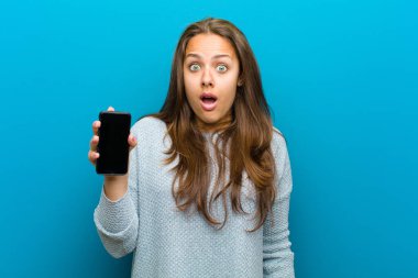 mavi arka plan karşı bir cep telefonu ile genç kadın
