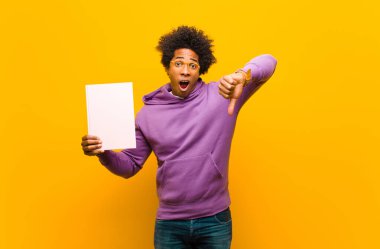 Genç Afrikalı Amerikalı adam turuncu arka plana karşı