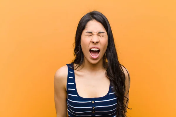 若いかなりヒスパニック系の女性は積極的に叫び 非常に怒っている 不満を持っている 怒りやいらいらしている 茶色の壁に対してノー叫び — ストック写真