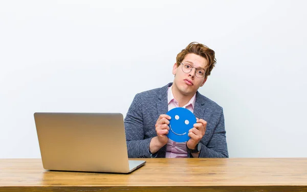 Joven Hombre Negocios Cabeza Roja Trabajando Escritorio Con Icono Cara — Foto de Stock